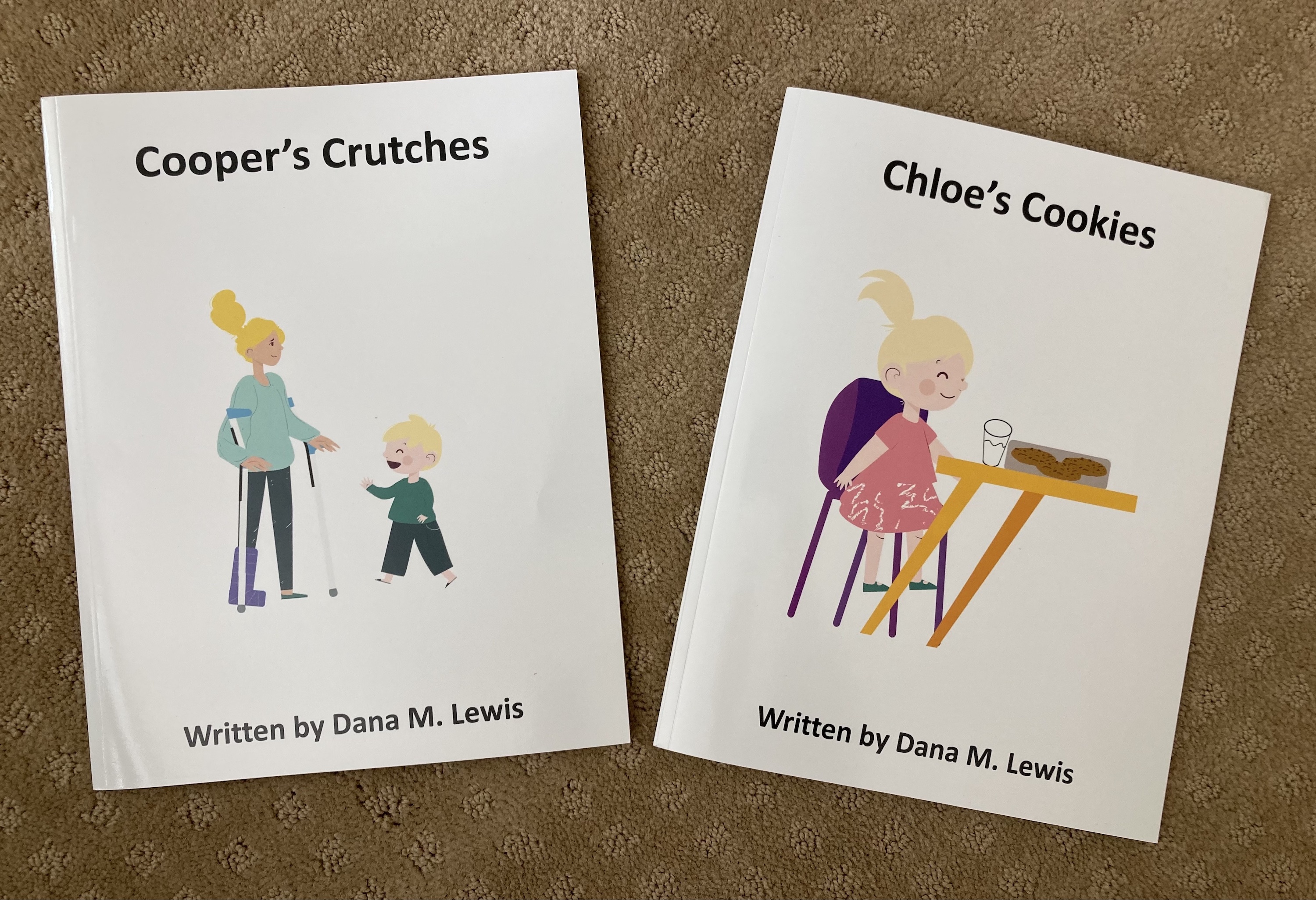 Two children's books lay on the carpet: Cooper's Crutches and Chloe's Cookies, both written by Dana M. Lewis