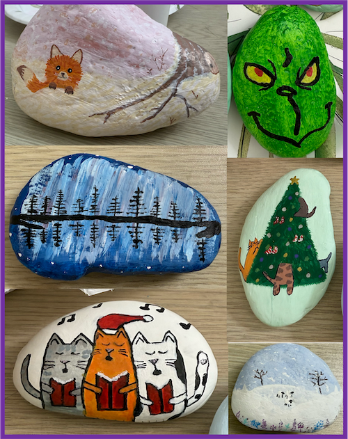 Examples of painted rocks including a fox peeking out from behind a snowbank next to a winter tree; a blue aurora reflected on a lake with trees; three cats doing christmas carols; a grinch; cats decorating a christmas tree; and a winter scene with sheep in a snowy field.